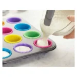 صب خليط الكيك داخل قوالب كب كيك سيليكون موضوعة في صينية الخبز