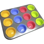 صور قوالب كب كيك سيليكون مرتبة في صينية معدنية قبل دخول الفرن