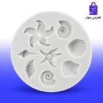 قالب سيليكون أبيض دائري متعدد التجاويف لأشكال أصدق البحر ونجوم البحر والقواقع البحرية المجسمة على خلفية رخامية مع تورتة ثيم البحر مزينة ومجسمات مصبوبة ملونة