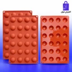 قالب سليكون أحمر للشوكولاتة والحلويات بتصميم كرات ونصف كرات 24 تجويف على خلفية بيضاء وزرقاء