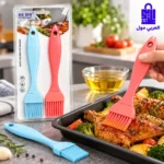 فرشاة سيليكون حمراء تغمس في وعاء الزيت وبجوارها توضيحات لمميزات المقاومة للحرارة وسهولة التنظيف