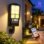 كشاف الطاقة الشمسية مثبت على جدار خارجي مضيء أثناء الليل مع يد تحكم عن بعد (Remote Control) توضح التحكم في أنظمة الإضاءة